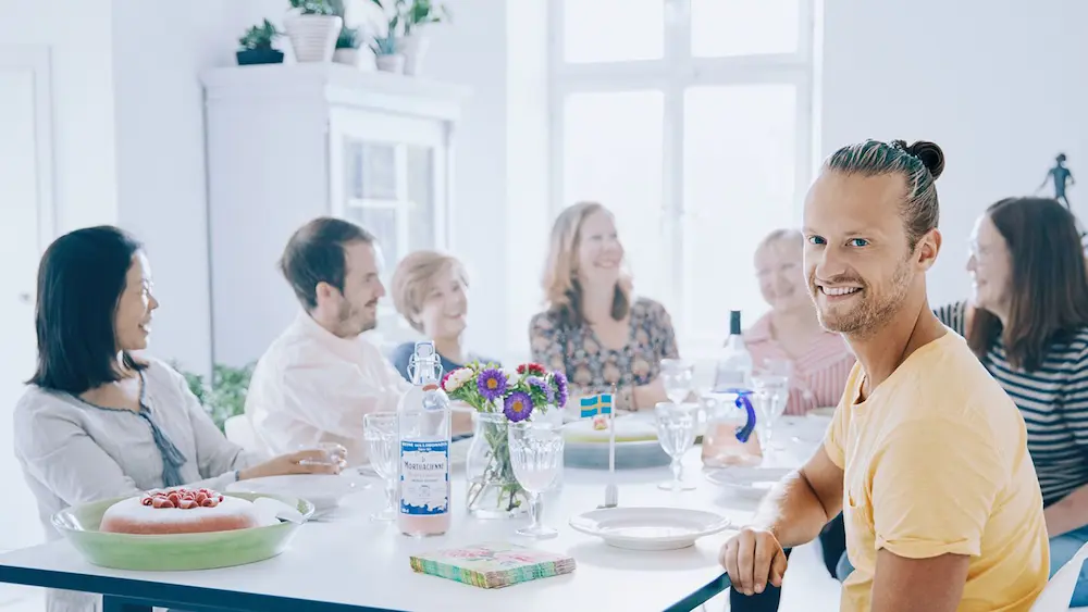 Glada personer som firar med tårta och flagga