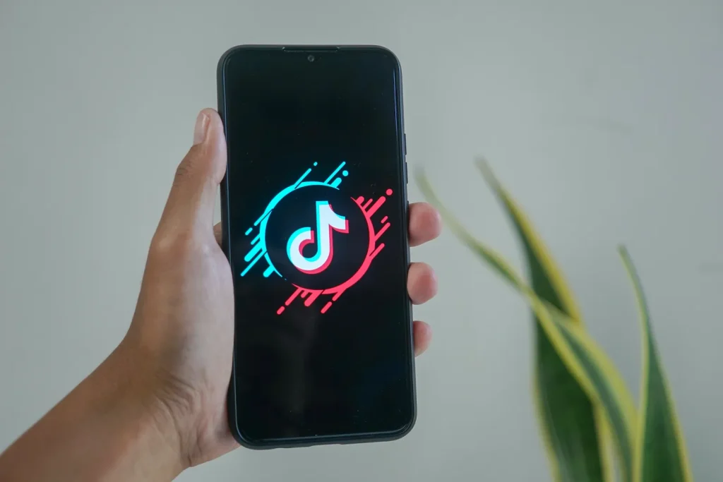 Hand holding a phone with TikTok-logo